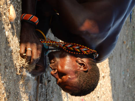 Kenia - Een man van de Samburu tribe die het vuur voor de avond maakt.