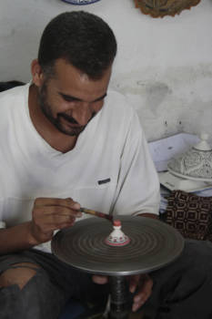 Marokko - De man werkt al vanaf zijn jeugd in een pottenfabriek en hij kleurt alles in. Hij deed het alsof het hartstikke makkelijk was