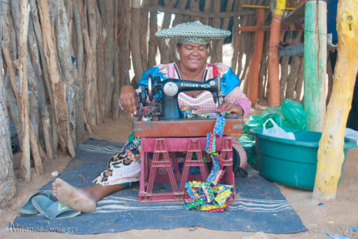 Namibië - Herero lady making souvenirs