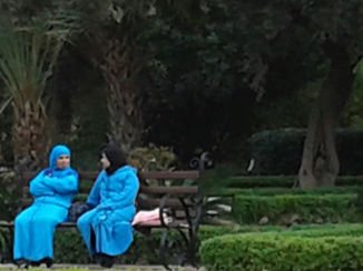 Marrakesh - Pratende dames in park dragen kleurige kleding.